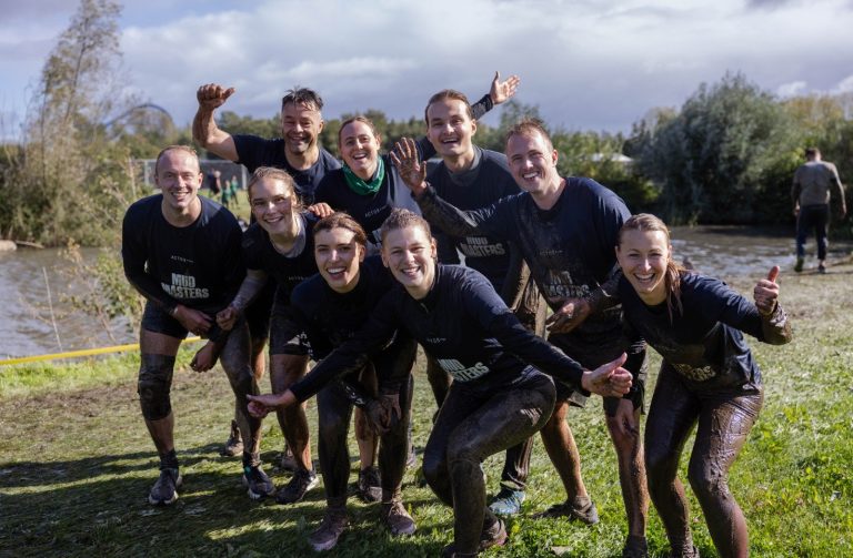 een foto van collega's, buiten, tijdens de mud masters obstakelrun